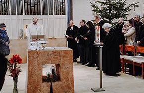 Gemeinde versammelt in einer Kirche mit einem Altar und einer festlichen Dekoration.