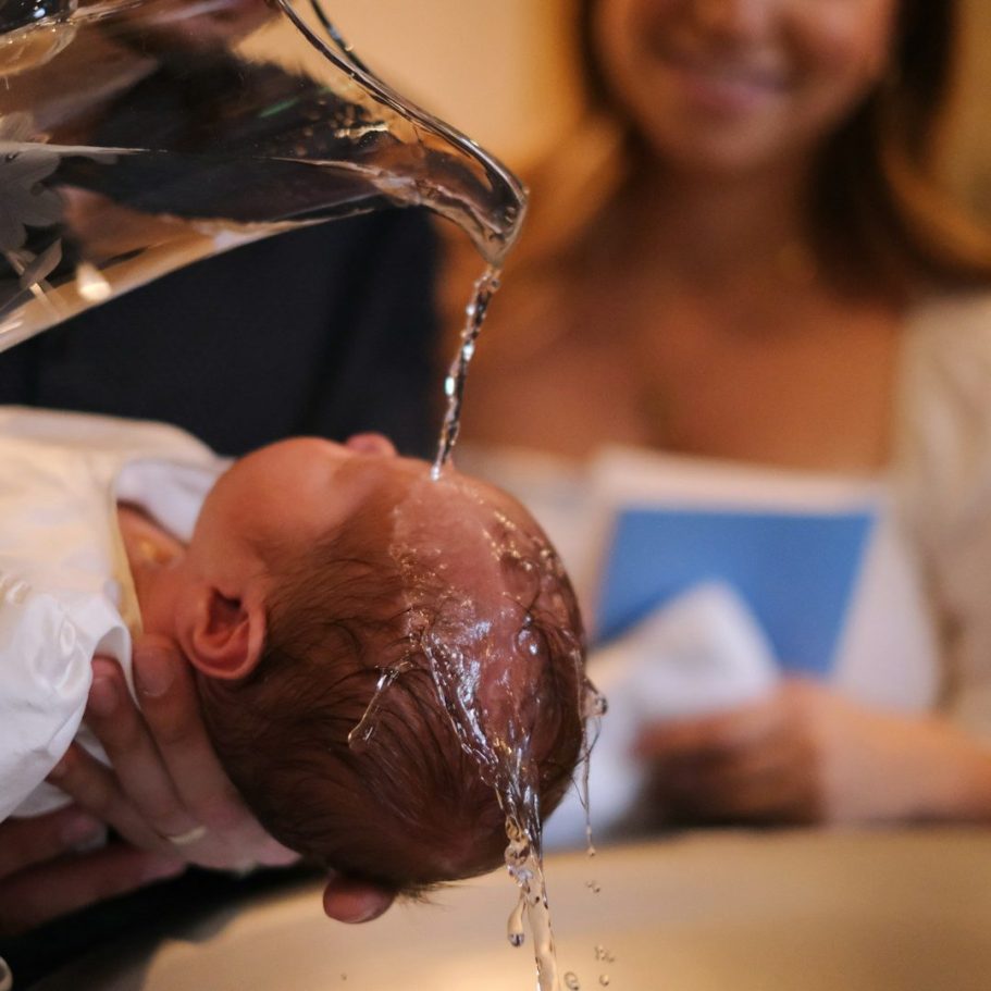 Ein Neugeborenes wird behutsam mit Wasser übergossen.