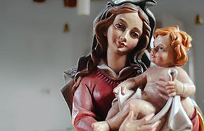 Maria mit Kind, detailreiche Statue in warmen Farben.