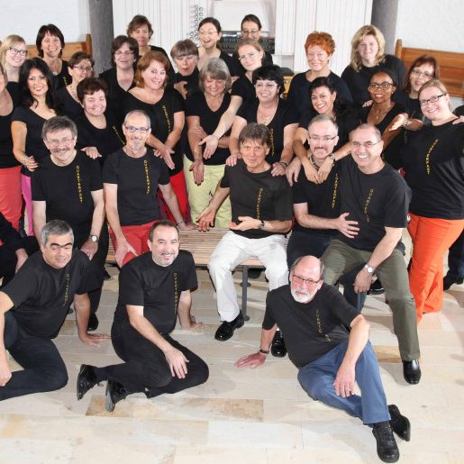 Eine große Gruppe von Menschen in schwarzen T-Shirts, lächelnd und posierend.